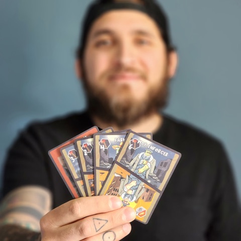 Erick, founder of Rising Warrior Games, holding a hand of Zombie Overlord cards